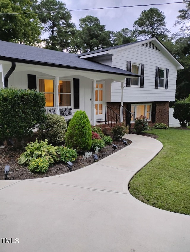 tri-level home with a front lawn and covered porch