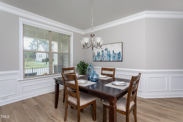 dining space featuring hardwood / wood-style flooring, a notable chandelier, and ornamental molding