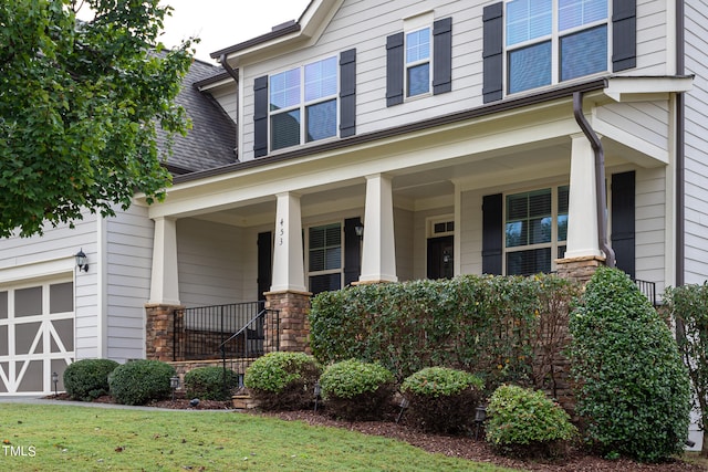 view of front of home featuring stone siding, a porch, roof with shingles, and an attached garage