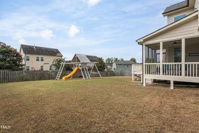 view of yard featuring a playground and a sunroom