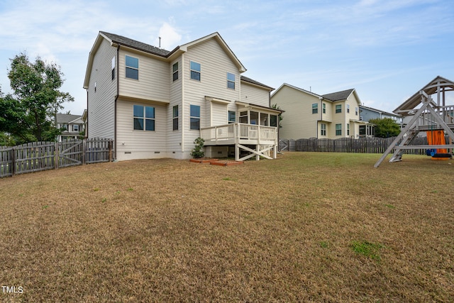 rear view of house featuring a playground, a lawn, a sunroom, crawl space, and a fenced backyard