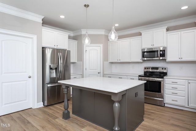 kitchen featuring stainless steel appliances, a center island, light countertops, and crown molding