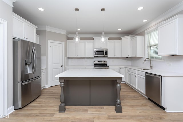 kitchen featuring white cabinetry, stainless steel appliances, a sink, and a center island