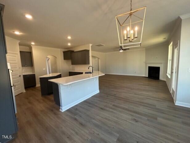 kitchen with a center island, a breakfast bar, dark brown cabinets, and dark hardwood / wood-style floors