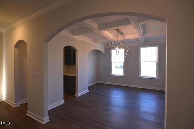 empty room with dark wood-type flooring, a chandelier, beam ceiling, crown molding, and coffered ceiling