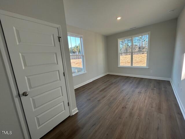 unfurnished dining area featuring plenty of natural light and dark wood-type flooring