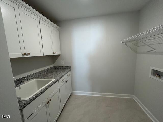 washroom featuring washer hookup, cabinets, and sink