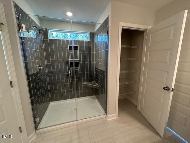 bathroom featuring tile patterned flooring and a shower with shower door