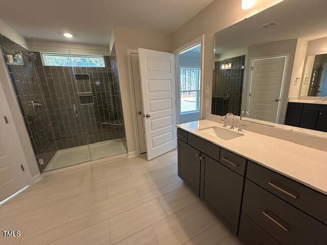 bathroom featuring a shower with door, vanity, and tile patterned floors