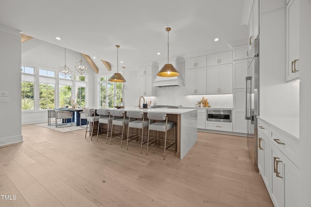 701 Dartmouth Rd, Raleigh, NC 27609 - kitchen with appliances with stainless steel finishes, recessed lighting, a breakfast bar area, light countertops, and light wood-style flooring