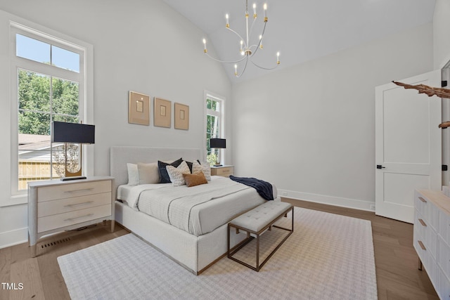 701 Dartmouth Rd, Raleigh, NC 27609 - bedroom with multiple windows, a chandelier, wood finished floors, and high vaulted ceiling