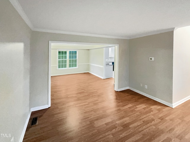 spare room with ornamental molding and wood-type flooring