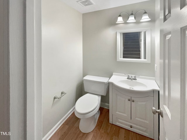 bathroom with wood-type flooring, vanity, and toilet