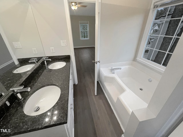 bathroom with a bath, vanity, ceiling fan, and hardwood / wood-style flooring