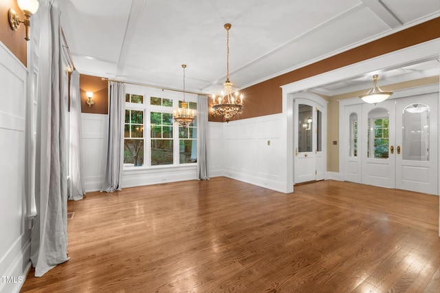 3105 Cone Manor Ln, Raleigh, NC 27613 - unfurnished dining area with a chandelier, a decorative wall, wood finished floors, wainscoting, and ornamental molding