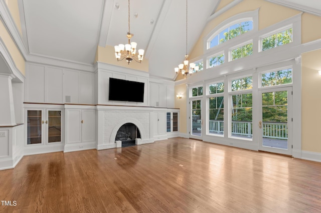 3105 Cone Manor Ln, Raleigh, NC 27613 - unfurnished living room featuring a chandelier, high vaulted ceiling, wood finished floors, a brick fireplace, and beamed ceiling