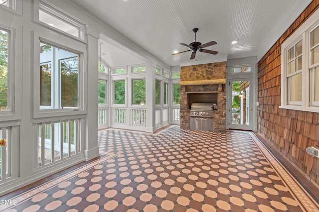 unfurnished sunroom with ceiling fan and plenty of natural light