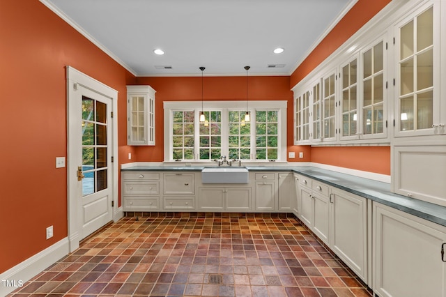 3105 Cone Manor Ln, Raleigh, NC 27613 - kitchen with ornamental molding, hanging light fixtures, plenty of natural light, glass insert cabinets, and recessed lighting