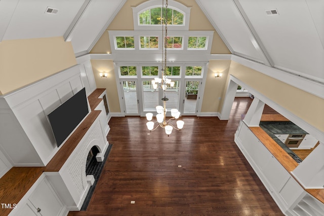 3105 Cone Manor Ln, Raleigh, NC 27613 - unfurnished living room featuring a chandelier, a fireplace, high vaulted ceiling, and dark wood-type flooring