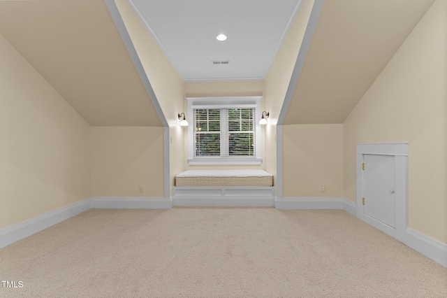 additional living space with light colored carpet and vaulted ceiling