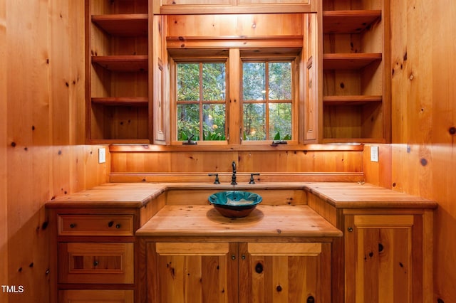 kitchen featuring wood counters, wood walls, and built in features