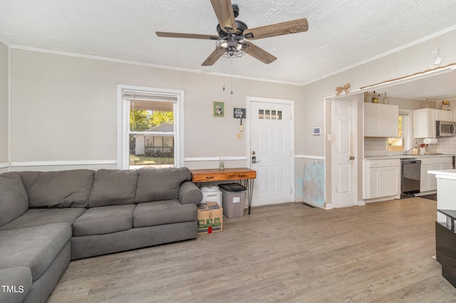 living room featuring a textured ceiling, crown molding, ceiling fan, and light hardwood / wood-style flooring