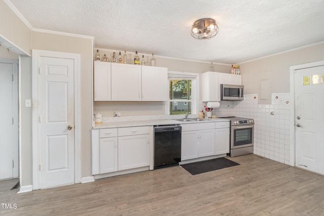 kitchen featuring light wood-type flooring, white cabinets, appliances with stainless steel finishes, and sink