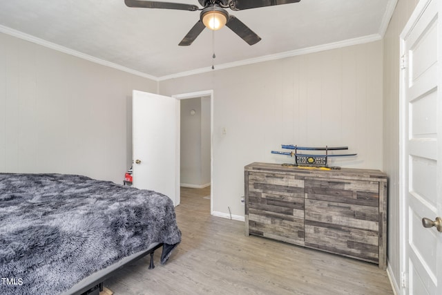 bedroom with crown molding, wood walls, ceiling fan, and light hardwood / wood-style flooring