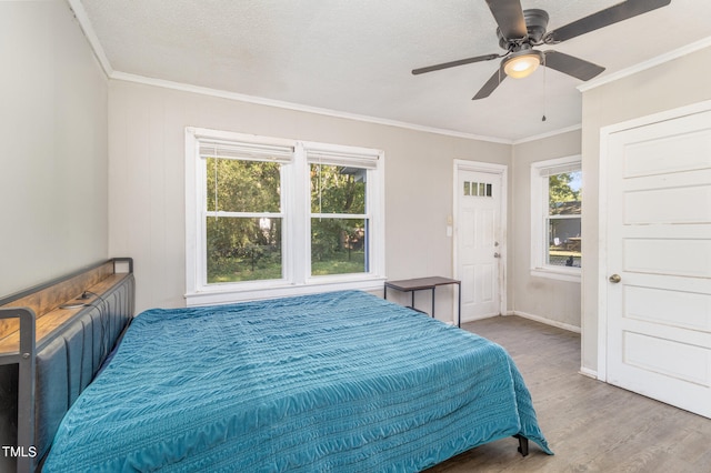 bedroom featuring a textured ceiling, ornamental molding, ceiling fan, and hardwood / wood-style flooring