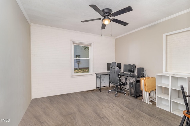 office area with ceiling fan, brick wall, a textured ceiling, crown molding, and hardwood / wood-style floors