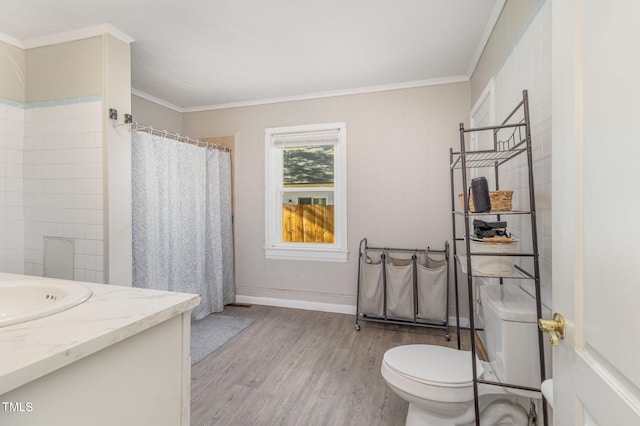 bathroom featuring wood-type flooring, crown molding, vanity, and toilet