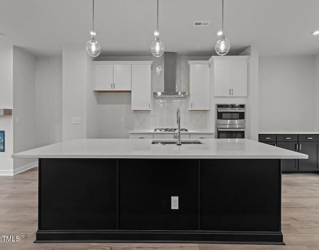4505 Mint Leaf Ln, Raleigh, NC 27612 - kitchen with wall chimney exhaust hood, stainless steel double oven, a large island, light countertops, and white cabinetry
