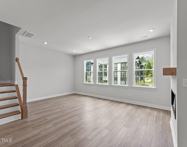 4505 Mint Leaf Ln, Raleigh, NC 27612 - unfurnished living room featuring wood finished floors, baseboards, a fireplace, stairs, and recessed lighting