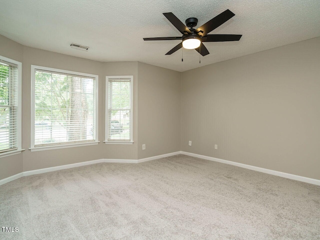 carpeted spare room featuring ceiling fan and a textured ceiling