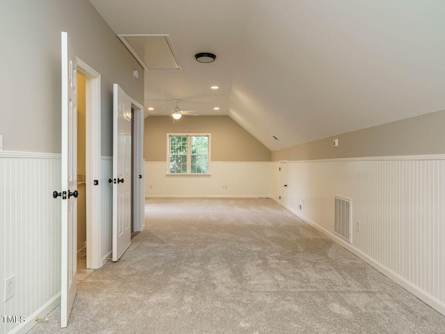 additional living space with light carpet and vaulted ceiling