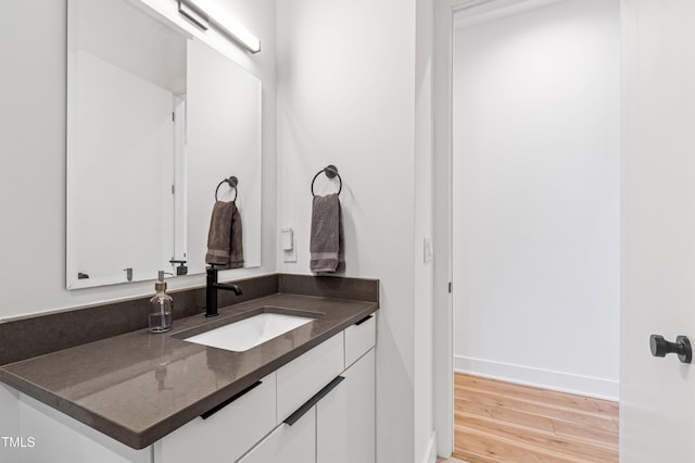 bathroom with baseboards, vanity, and wood finished floors