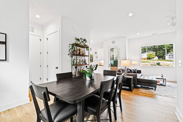 dining area with light hardwood / wood-style flooring and ceiling fan