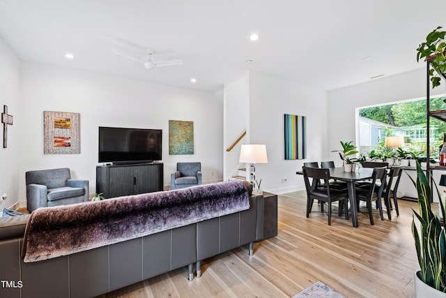 living room with baseboards, stairs, light wood finished floors, and recessed lighting