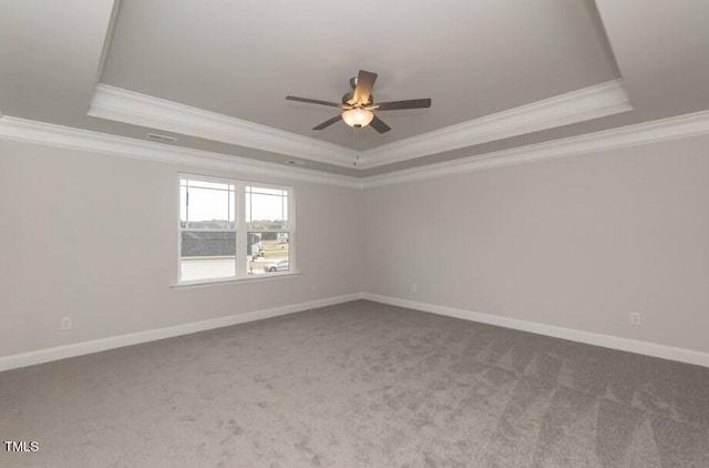 carpeted spare room featuring ceiling fan, ornamental molding, and a raised ceiling