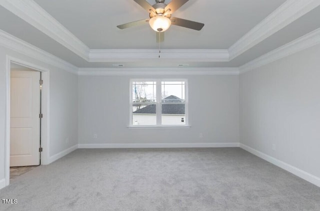 carpeted empty room featuring ceiling fan, a tray ceiling, and ornamental molding