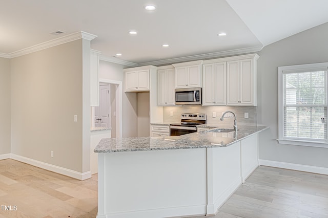 kitchen with kitchen peninsula, white cabinetry, stainless steel appliances, and light stone counters