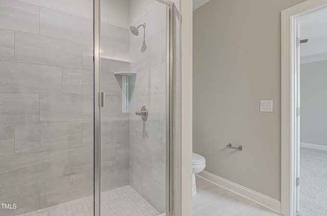 bathroom featuring toilet and an enclosed shower