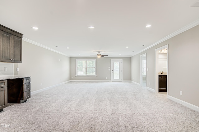 unfurnished living room with ornamental molding, ceiling fan, and light carpet