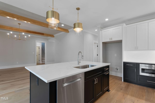 kitchen with stainless steel appliances, light wood-type flooring, decorative light fixtures, sink, and a kitchen island with sink