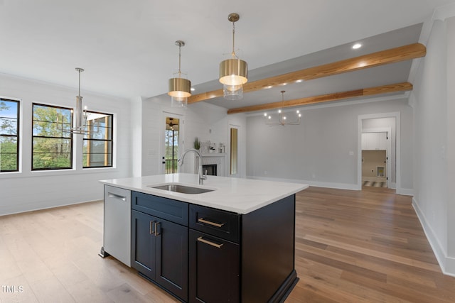 kitchen with beamed ceiling, a center island with sink, sink, decorative light fixtures, and stainless steel dishwasher