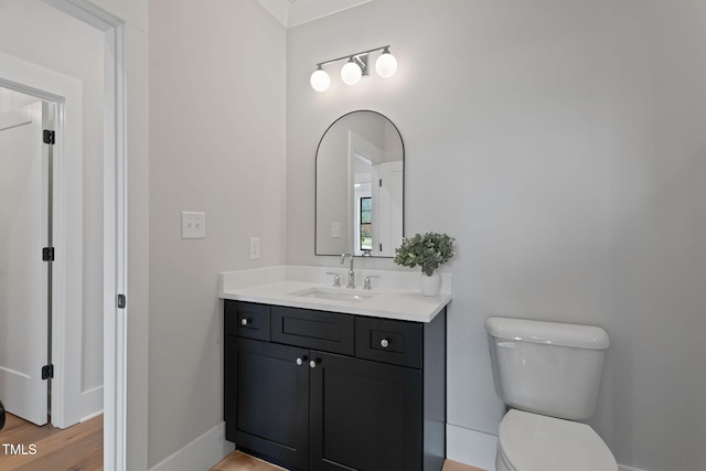 bathroom with hardwood / wood-style flooring, vanity, and toilet