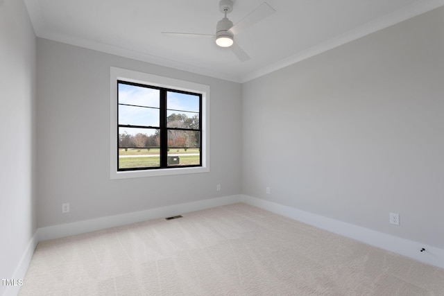 carpeted spare room with ceiling fan and crown molding