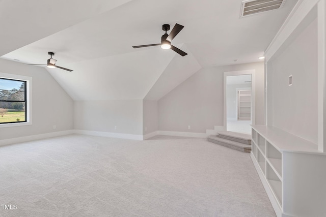 additional living space featuring light carpet, ceiling fan, and vaulted ceiling