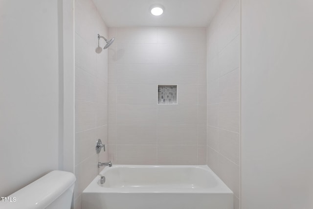 bathroom with tiled shower / bath and toilet