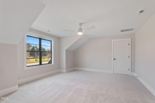 additional living space featuring vaulted ceiling, light carpet, and ceiling fan